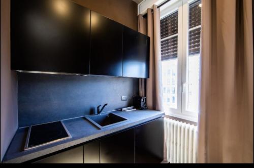 - une cuisine avec un évier et un comptoir avec une fenêtre dans l'établissement AMAZING NEW SUITE WITH BEAUTIFUL VIEW from Moscova Suites apartments group, à Milan