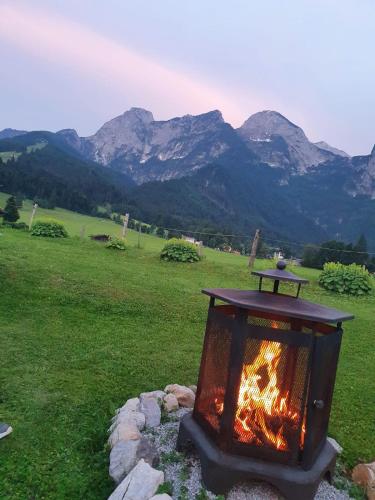 a fireplace in a field with mountains in the background at Landhaus Algerhof in Abtenau