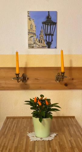 a vase of oranges on a table with two candles at Haus Grüne Idylle in Bannewitz