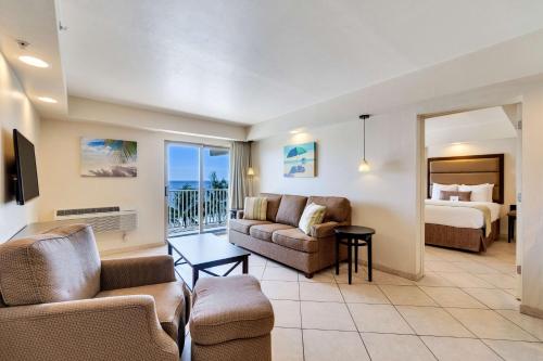 Best Western Plus Beach Resort في فورت مايرز بيتش: غرفة معيشة مع أريكة وسرير