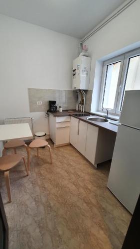 cocina con armarios blancos, mesa y fregadero en Casa Florescu 13, en Bucarest