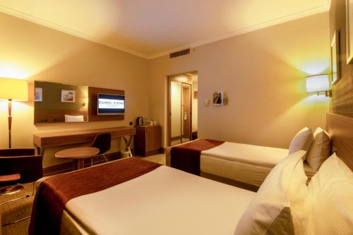 a hotel room with two beds and a desk at Euro Park Hotel Bursa in Bursa