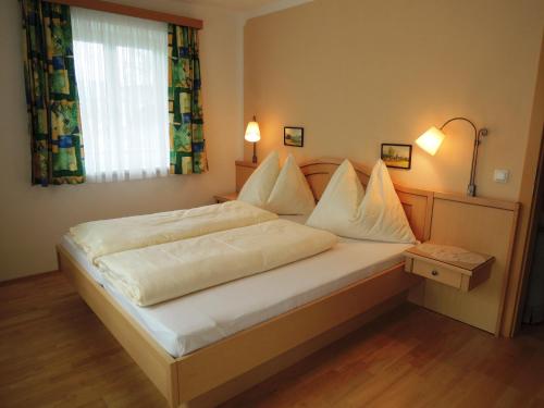 Appartements Edda في شتروبل: غرفة نوم بسرير وملاءات بيضاء ونافذة
