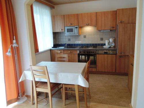 Appartements Edda في شتروبل: مطبخ مع طاولة وكرسيين وطاولة وميكرويف