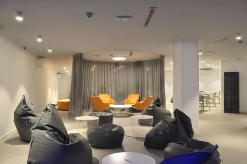 a living room with orange chairs and a table at Residencia Universitaria Málaga Centro in Málaga