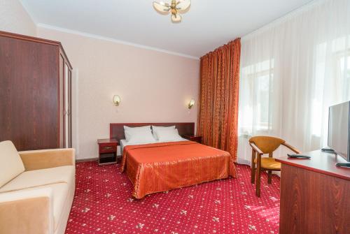 a hotel room with a bed and a couch at Отель Застава in Anapa