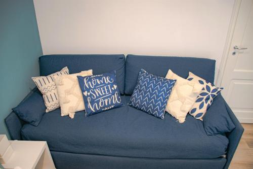 a blue couch with pillows on it in a living room at Casa AZZURRA 61Mq a 30 metri dalla Reggia di Venaria in Venaria Reale