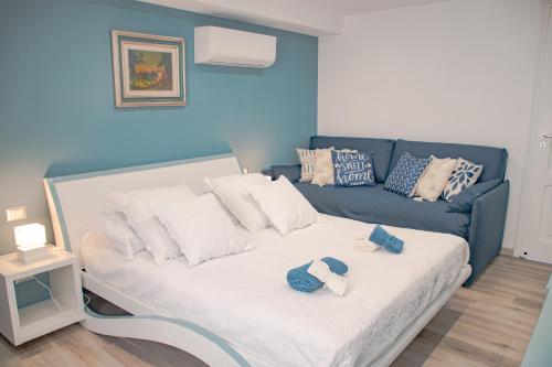 a blue room with a bed and a blue couch at Casa AZZURRA 61Mq a 30 metri dalla Reggia di Venaria in Venaria Reale