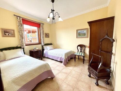 a bedroom with two beds and a chair in it at CASA Mar y Teide in Sauzal