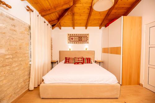 a bedroom with a bed and a wooden ceiling at Vila Leon - Old Qeparo in Qeparo