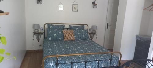 1 dormitorio con 1 cama con almohadas azules en Arche de Lanoë jacuzzi, en Labastide-Saint-Pierre