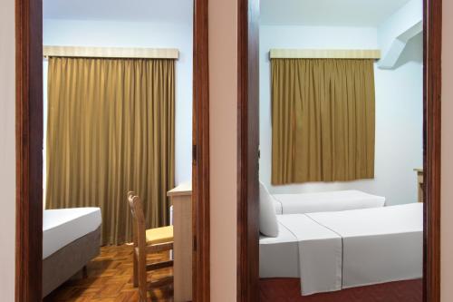 a room with two beds and a mirror at Hotel Euro Suite Poços de Caldas By Nacional Inn in Poços de Caldas