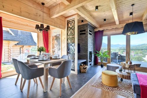 a living room with a dining room table and chairs at Osada Bachledzki Wierch Odkryj Zakopane in Zakopane