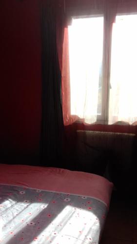 - une chambre avec un lit et une fenêtre avec des draps rouges dans l'établissement Le petit coin tranquille, à Signes