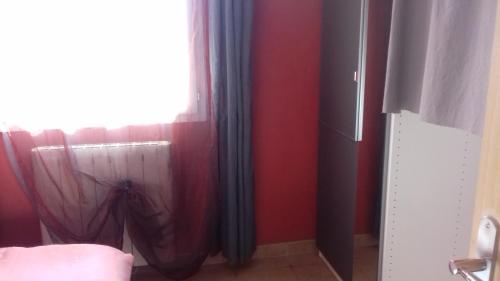 - une chambre aux murs rouges et une fenêtre avec un parasol dans l'établissement Le petit coin tranquille, à Signes