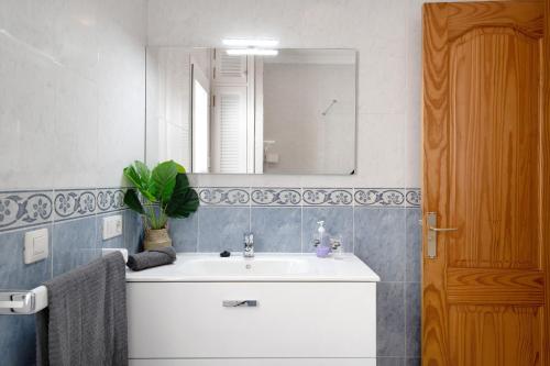 ein Badezimmer mit einem weißen Waschbecken und einem Spiegel in der Unterkunft La Bonanza in Playa Blanca