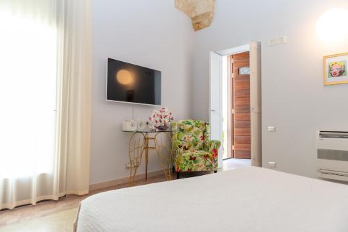 a bedroom with a bed and a chair and a television at Monteforte Resort in Ugento
