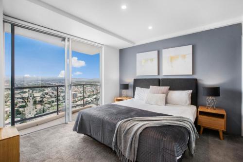 a bedroom with a large bed and a large window at Chevron Renaissance 2 Bed Apartment by Vaun in Gold Coast