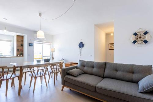 a living room with a couch and a table at Cozy ap renovado 1ª linha de Praia - Armação Pêra in Armação de Pêra
