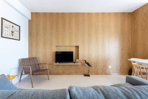 a living room with a couch and a tv at Cozy ap renovado 1ª linha de Praia - Armação Pêra in Armação de Pêra