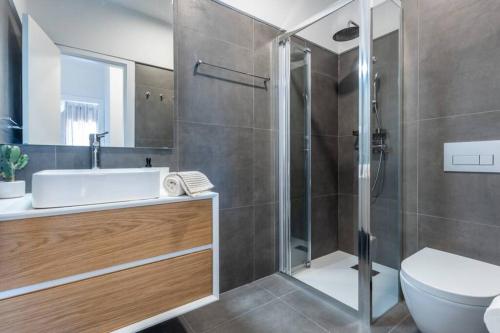 a bathroom with a shower and a sink and a toilet at Cozy ap renovado 1ª linha de Praia - Armação Pêra in Armação de Pêra