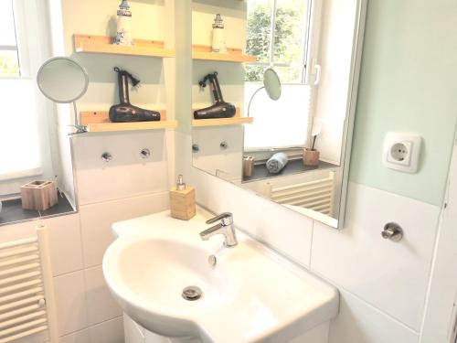 a bathroom with a sink and a mirror at Gästehaus "Duvenstedter Brook" 