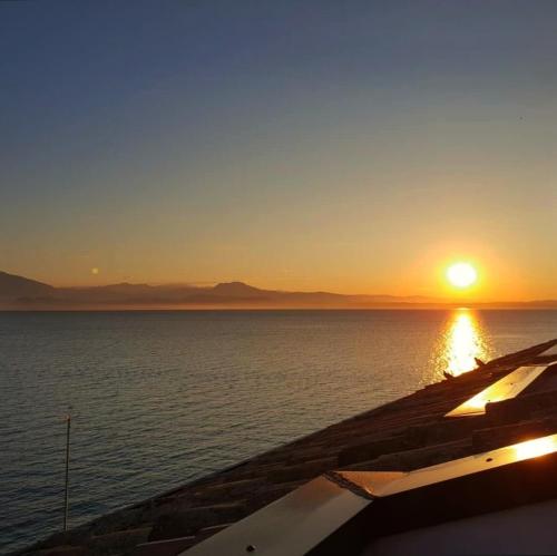 a sunset over the ocean with the sun in the sky at Hotel Grifone in Sirmione