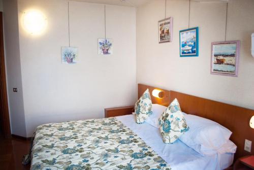 a bedroom with a bed with pillows on it at Hotel Grifone in Sirmione