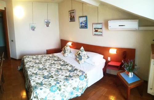 a bedroom with a bed with a floral bedspread at Hotel Grifone in Sirmione
