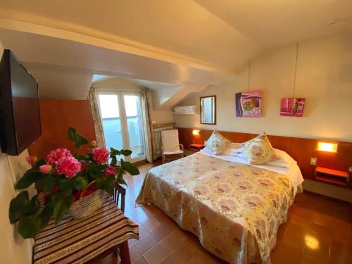 a bedroom with a bed and a vase of flowers at Hotel Grifone in Sirmione