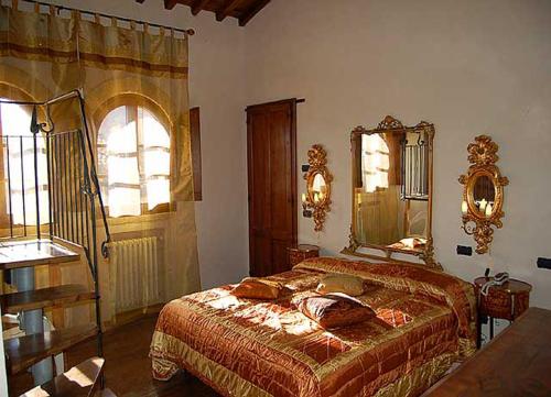 1 dormitorio con cama y espejo grande en Residenza D'epoca Il Biribino, en Città di Castello