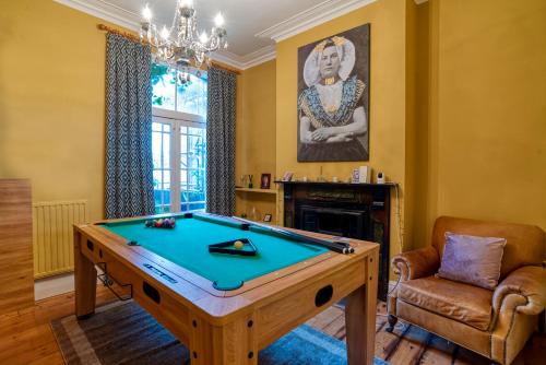 a living room with a pool table and a chandelier at The Beach House - Cromer in Cromer