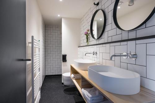 a bathroom with two sinks and a mirror at Stadshotel Steegoversloot in Dordrecht