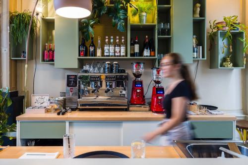 a woman walking in front of a bar at Stadshotel Steegoversloot in Dordrecht