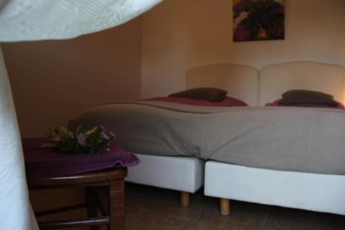 a bedroom with a bed and a table with flowers on it at Pensionszimmer im Fliederhof in Michendorf