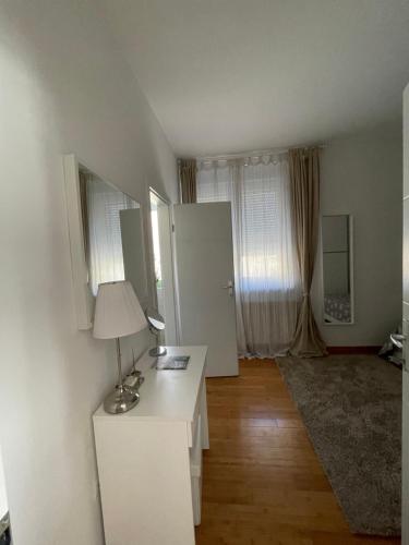 Cette chambre dispose d'un bureau blanc avec une lampe. dans l'établissement Marimar apartments, à Zagreb