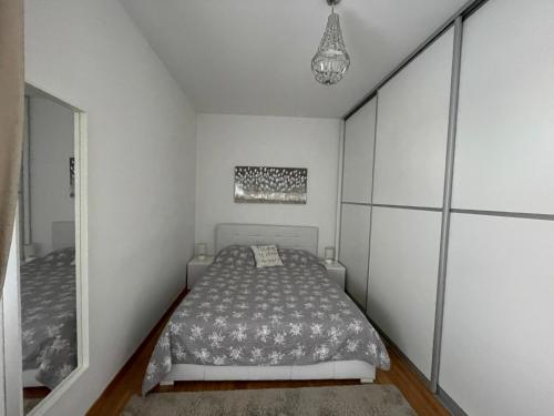 een witte slaapkamer met een bed en een spiegel bij Marimar apartments in Zagreb