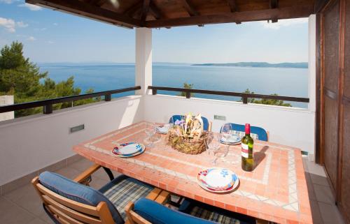 a table on a balcony with a view of the water at Apartments Fani in Brela