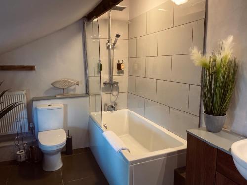 a bathroom with a tub and a toilet and a sink at The Riverside Rooms in Newark upon Trent