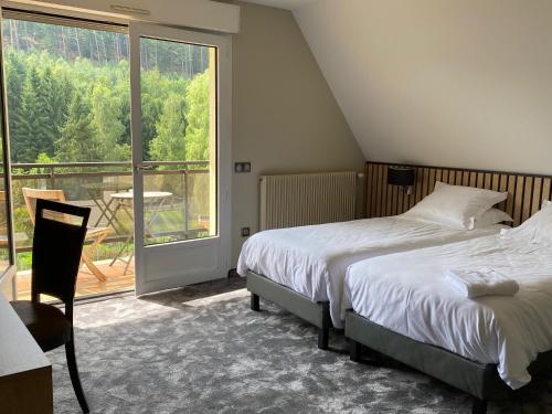 a bedroom with a bed and a large window at Hôtel Restaurant La Couronne by K in Reipertswiller