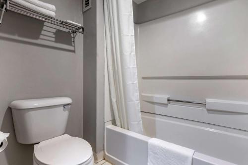 La salle de bains blanche est pourvue de toilettes et d'une baignoire. dans l'établissement Econo Lodge, à Saint Stephen