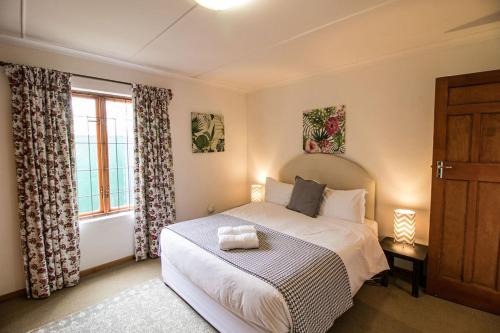 1 dormitorio con cama y ventana en Garden Cottage, en Graaff-Reinet