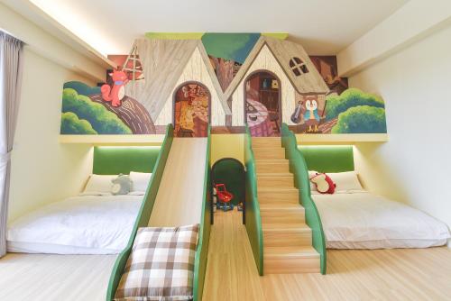a room with two beds and a mural of a house at Bubble Forest in Taitung City