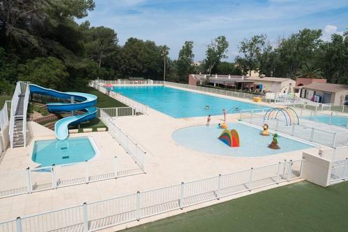 une grande piscine avec un toboggan et un parc aquatique dans l'établissement location saisonnière belle vue sur mer, à Six-Fours-les-Plages