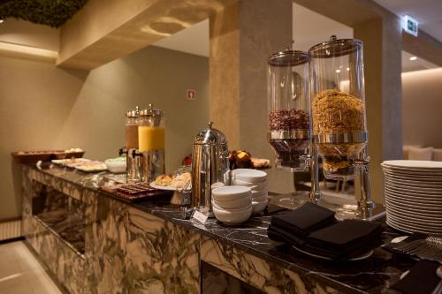 a buffet with plates and food on a table at OMID Saldanha Hotel in Lisbon