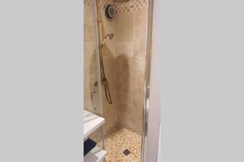 um chuveiro com uma porta de vidro na casa de banho em studio entre vallée colline et soleil marseillais em Marselha