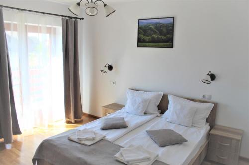 a bedroom with a bed with two pillows on it at Pensiunea Nobila in Beclean