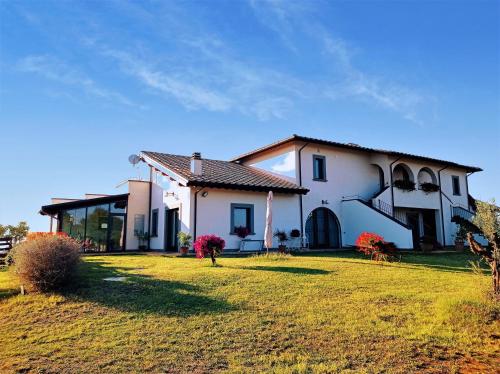 Grotte di CastroにあるAgriturismo PIAN DEL GRANO Azienda agricolaの芝生の庭のある大きな白い家