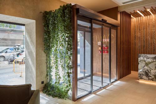 a lobby of a building with a plant on the wall at OMID Saldanha Hotel in Lisbon