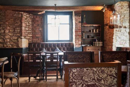 a dining room with leather chairs and a window at The Kings Arms in Woodstock